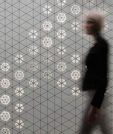 Une femme passe devant un mur intérieur décoré avec Philips Luminous Patterns – expérience client