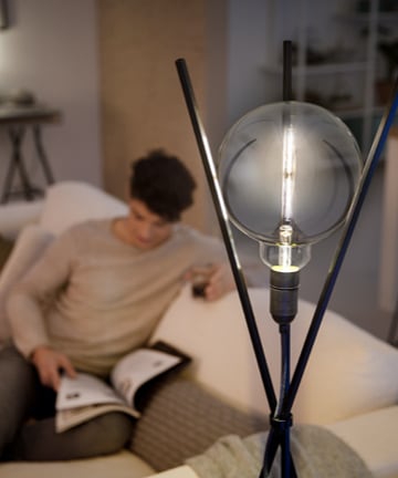 Un homme lit à la lueur d'une ampoule à DEL Philips d'allure moderne 