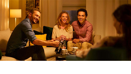 People enjoying the warm glow of a dimmed light bulb in a living room