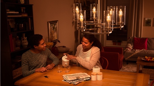 Deux personnes assises à la lueur d'un éclairage à DEL de haute qualité sur un divan à la maison