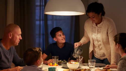Une famille soupe à la maison à une table à manger bien éclairée