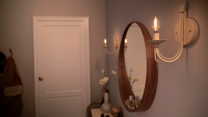 Des ampoules en forme de bougie installées des deux côtés d'un miroir d'entrée