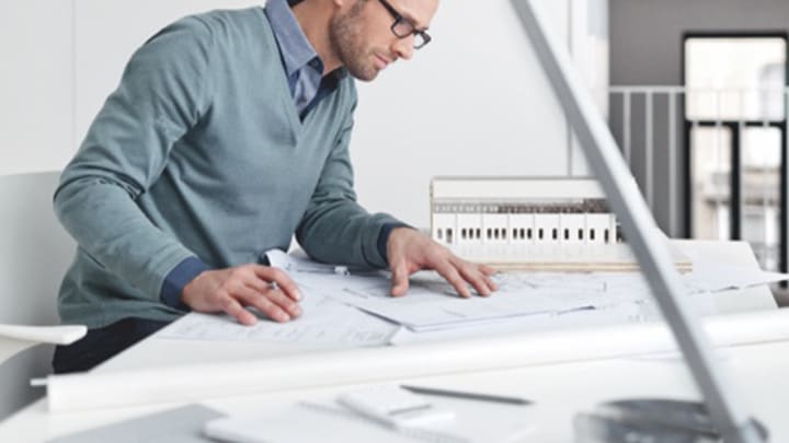 un homme travaillant à domicile sur un bureau encombré