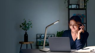"Child studying at desk with adjustable LED task lamp, providing optimal illumination for homework in colorful home learning space."