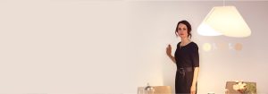 "Femme ajustant l’éclairage lumineux encastré à DEL via un gradateur mural élégant, améliorant l’ambiance et l’efficacité énergétique du salon moderne."
