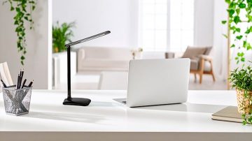 Une lampe de table orientée vers du papier et un crayon sur un bureau
