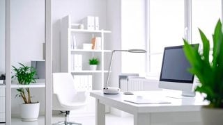 Une pièce blanche éclatante montre un bureau avec un ordinateur et une lampe de table dessus