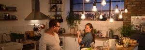 "Cuisine moderne avec des lumières suspendues DEL de style rétro illuminant deux femmes qui savourent le dîner, créant une atmosphère chaleureuse et accueillante."