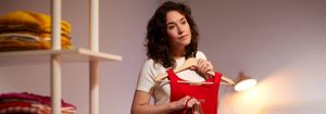 "La lampe de bureau à DEL chaude illumine la femme sélectionnant des vêtements, mettant en valeur un éclairage de tâche écoénergétique pour un style personnel dans l’espace du placard à la maison. »