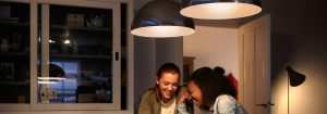 "Les lampes suspendues à DEL modernes créent une atmosphère chaleureuse pour deux femmes profitant d'une conversation, présentant des solutions d’éclairage domestique écoénergétiques."